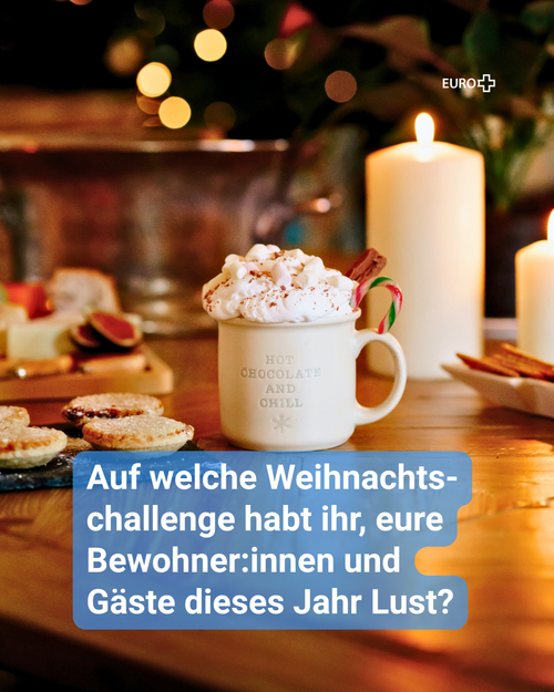 Festlich gedeckter Tisch mit heißer Schokolade, Gebäck und Kerzenschein – Einladung zur EURO+ Weihnachtschallenge 2025. Text: „Auf welche Weihnachtschallenge habt ihr, eure Bewohner:innen und Gäste dieses Jahr Lust?“